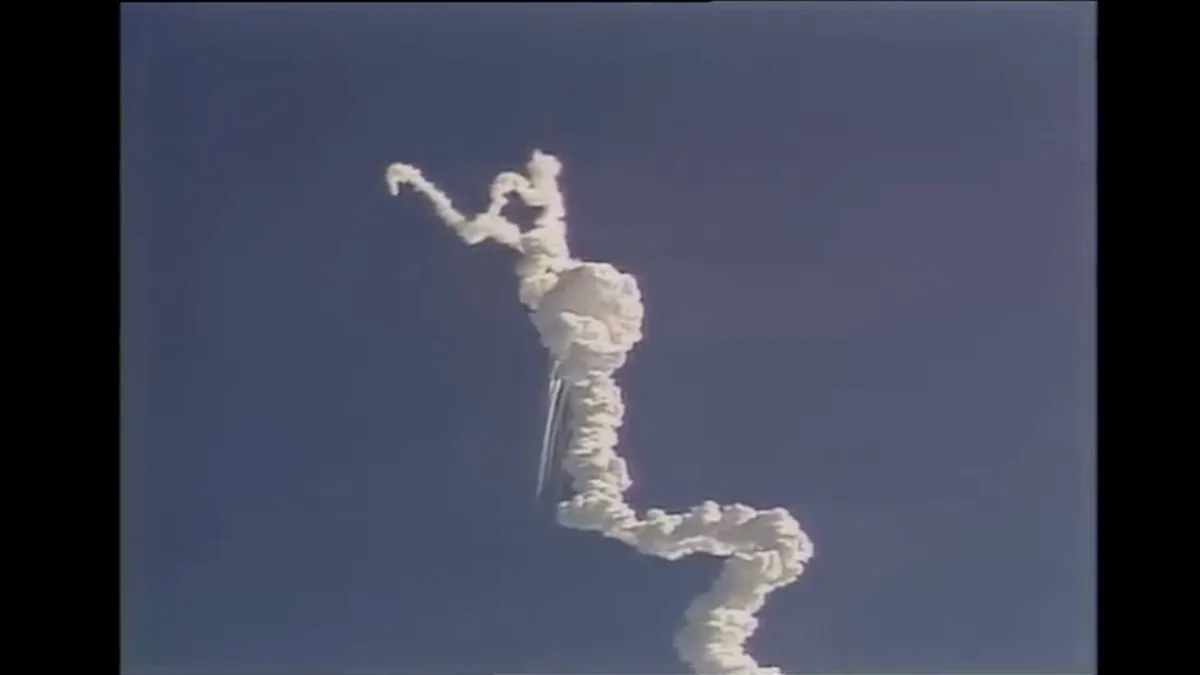 Nuvem icônica em forma de Y formada após a desintegração do ônibus espacial Challenger, com os boosters caindo em trajetórias divergentes