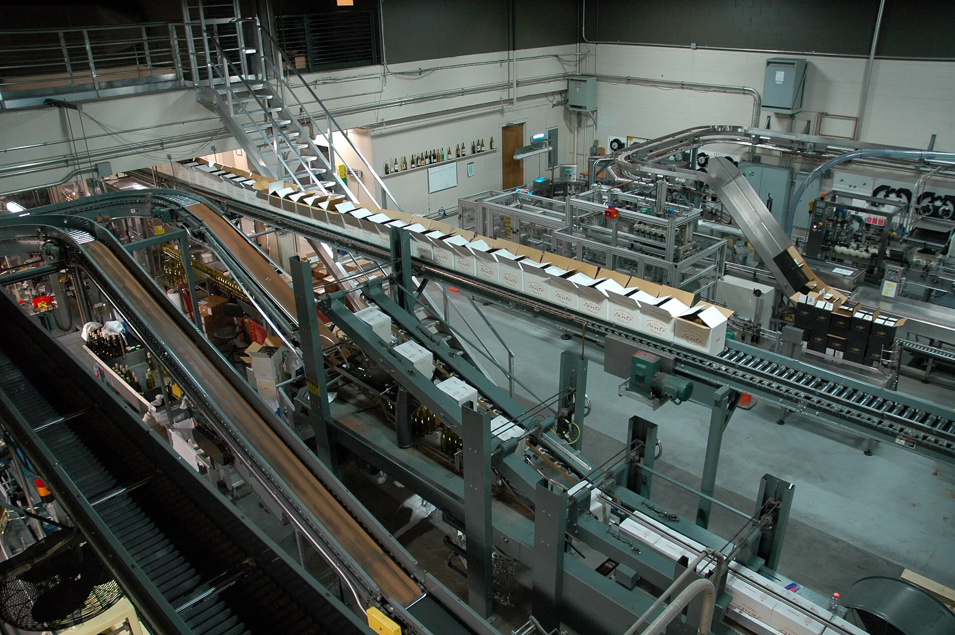 Industrielle Abfüll- und Verpackungslinie für Getränke mit Förderbändern und Maschinen in einer großen Halle