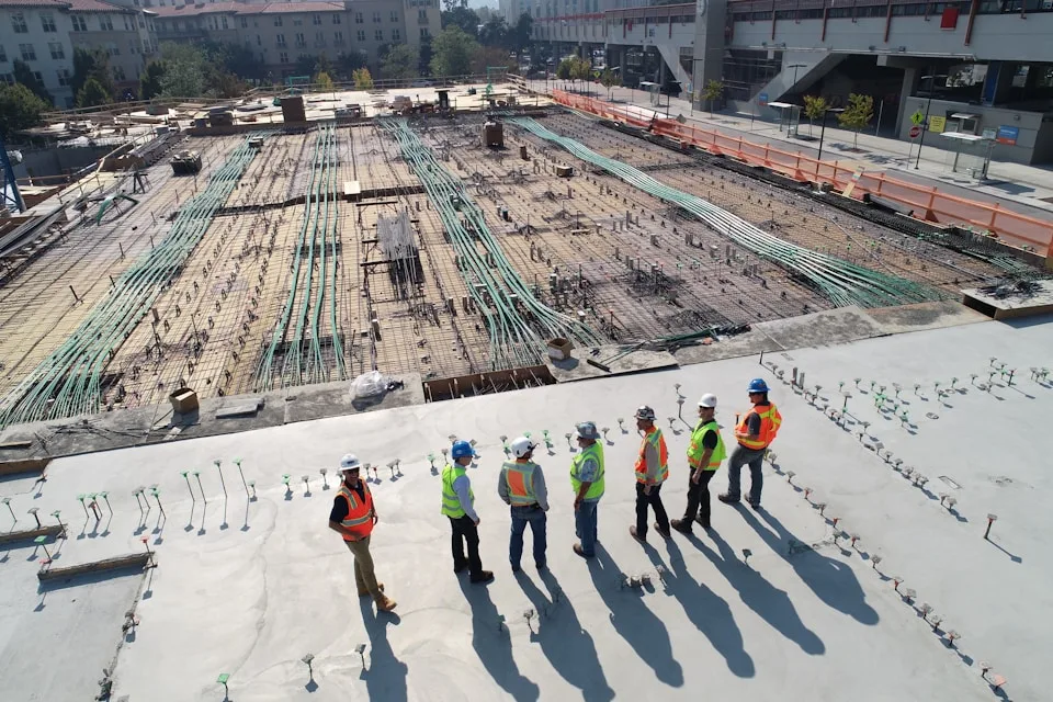 Team mit Helmen und Warnwesten auf einer Baustelle